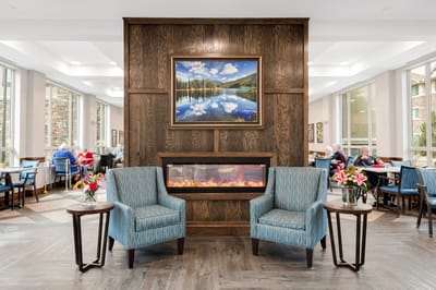 Common area with chairs, fireplace, and residents