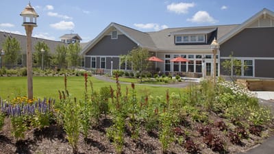 Exterior view of assisted living facility with garden