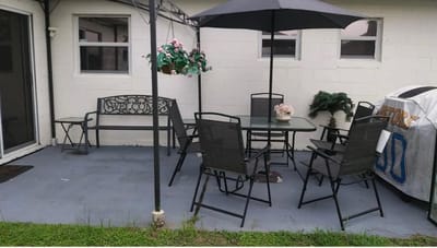 Outdoor seating area with table and chairs under an umbrella