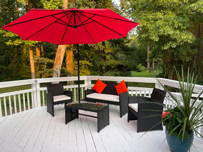 Outdoor seating area with red umbrella and greenery