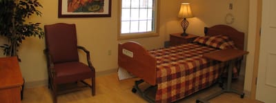 Interior view of a resident room with bed and chair
