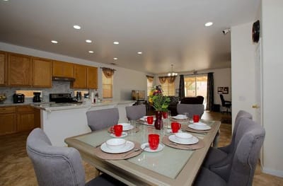 Dining room set up for a meal with flowers and red dishes
