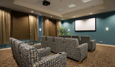 Seating area in a media room with a projector screen