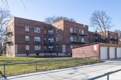 Brick exterior of the Bayside Manor building with green space