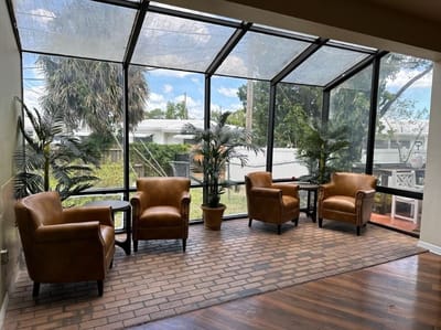 Cozy sunroom with chairs and potted plants