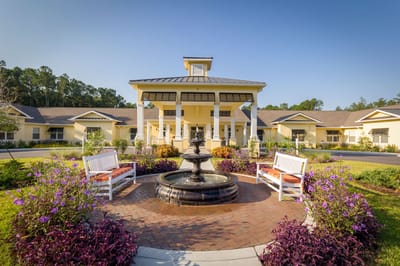 Front entrance of a senior living facility with landscaped gardens