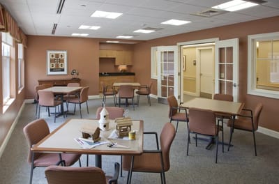 Common area with tables and chairs in a warm setting