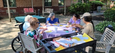 Residents engaged in a craft activity outdoors