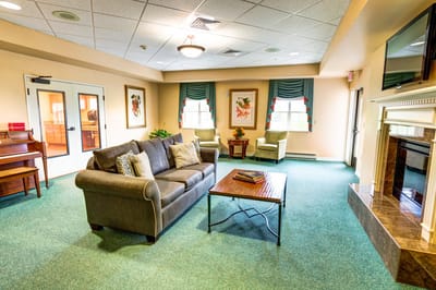 Bright and cozy common area with seating and piano
