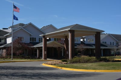 Entrance of a senior living facility with flag poles