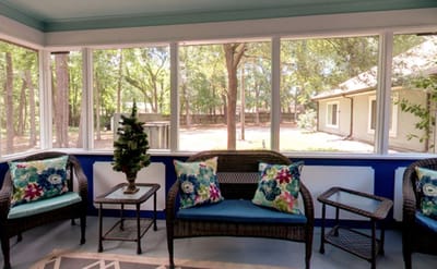Bright sunroom with wicker furniture and greenery outside