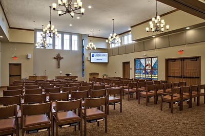 Interior view of a chapel with rows of wooden chairs
