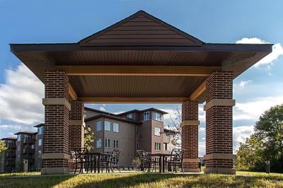 Outdoor seating area with a pavilion near the facility