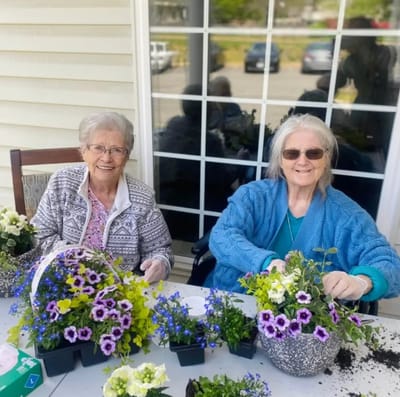 Two residents enjoying planting flowers outdoors