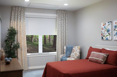 Cozy resident room with a red bedspread and window view