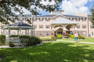 Residents walking in the outdoor garden area of the facility