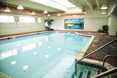 Indoor pool area with mural and jacuzzi