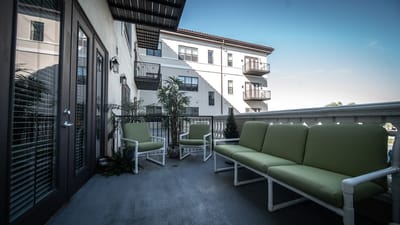 Outdoor seating area with green chairs and building in background
