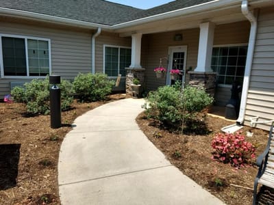 Pathway leading to the entrance of the facility with gardens