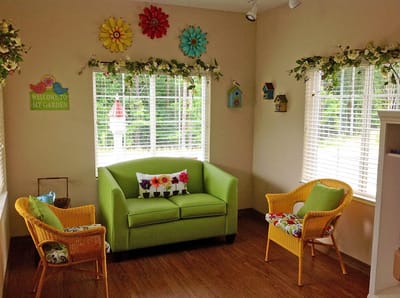 Bright common area with green seating and floral decor