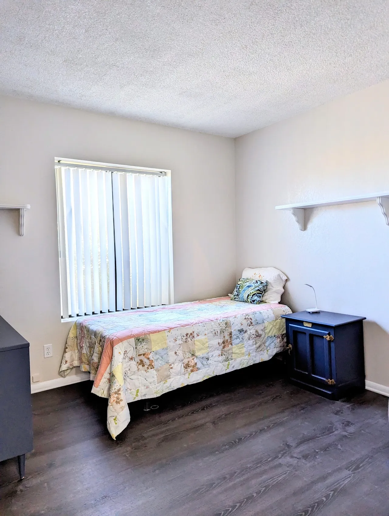 Cozy single resident room with a bed and dresser