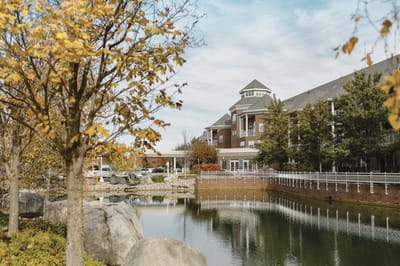 Exterior view of a senior living facility with landscaped pond