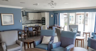 Bright common area with seating and a kitchenette