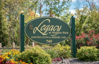 Sign for Legacy at Maiden Park with gardens and flowers