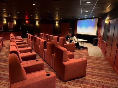 Interior view of a movie room with red seating and screen