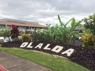 Outdoor signage with tropical plants at Olaloa Retirement Community