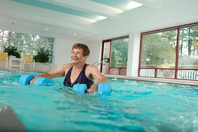 Senior participating in water exercise in an indoor pool