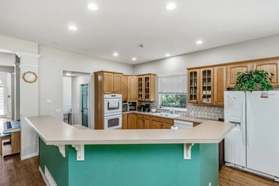 Bright kitchen area with wooden cabinets and green accents