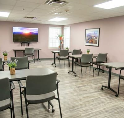 Bright communal activity room with tables and chairs