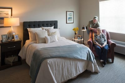 Resident with staff member in a cozy bedroom