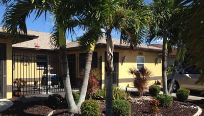 Exterior view of a residential care building with palm trees
