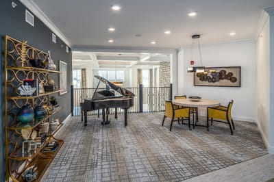 Bright common area with piano and dining table