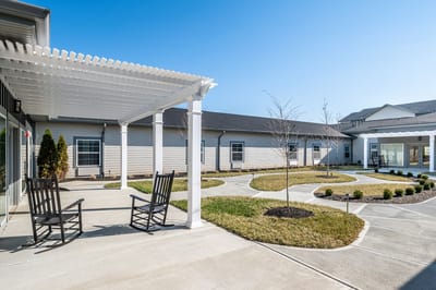 Outdoor seating area with rocking chairs and landscaping