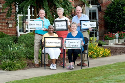 Residents holding signs representing values in a garden area