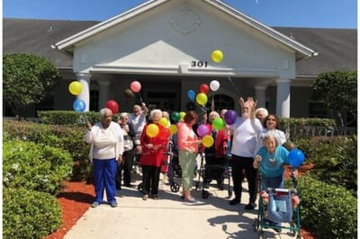 Residents celebrating outside with colorful balloons