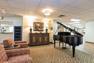 Interior view of a common area with a piano and seating