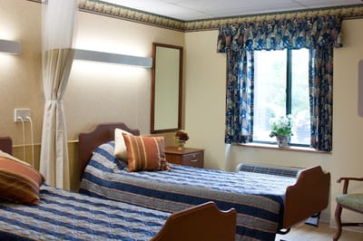 A shared resident room with two beds and a window