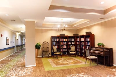 Cozy common area with a bookshelf and piano