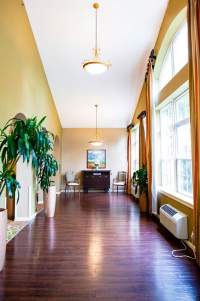 Interior common area with large windows and plants