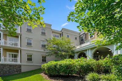 Exterior view of a senior living facility surrounded by greenery