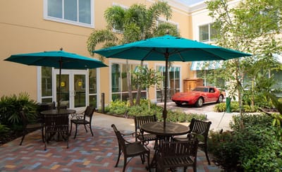 Outdoor courtyard with umbrellas and a classic car