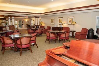 Common area with seating and a piano in a senior living facility