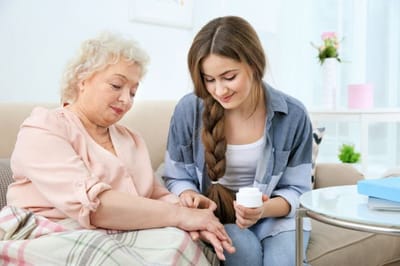Caregiver assisting a resident in a cozy living room