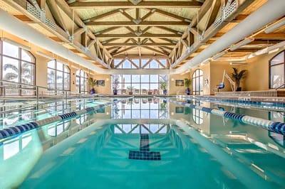 Indoor swimming pool area with skylights and wooden beams