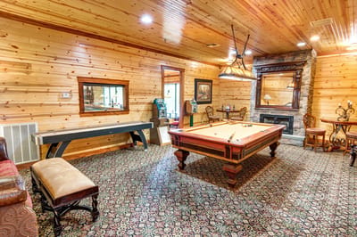 A cozy recreation room with a pool table and wooden decor