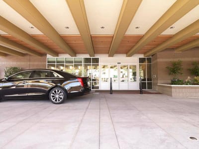 Front entrance of a senior care facility with a vehicle.